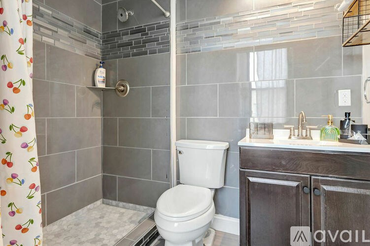 A bathroom with a toilet, sink, and shower.
