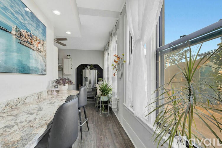 A modern dining room with a marble table and chairs.