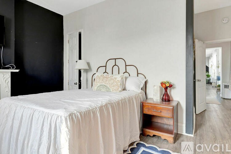 A bedroom with a bed, nightstand, and a lamp.