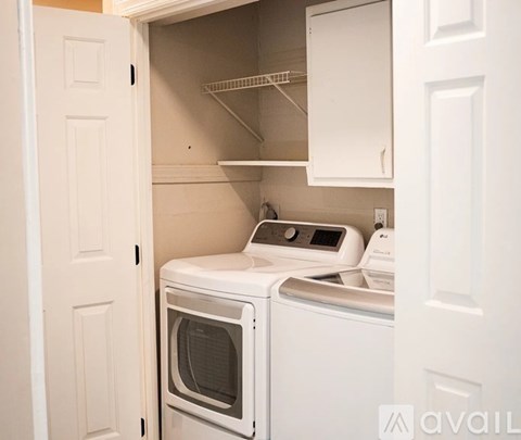 A white dryer and washer are in a small laundry room.