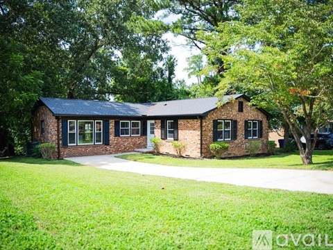 A house with a green lawn in front of it.