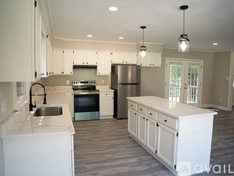 A kitchen with white cabinets and a stainless steel refrigerator.