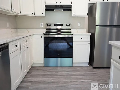 A modern kitchen with a stainless steel refrigerator and a stove top oven.