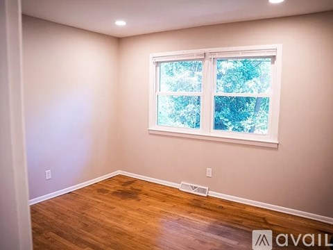 A room with a window and wooden flooring.