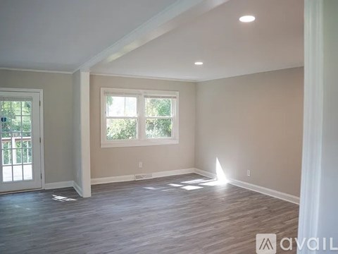 A room with wooden flooring and a window.