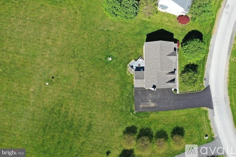 A house with a grey roof is surrounded by a grassy area.