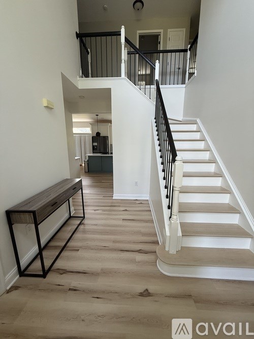 A staircase with a black railing and white steps.