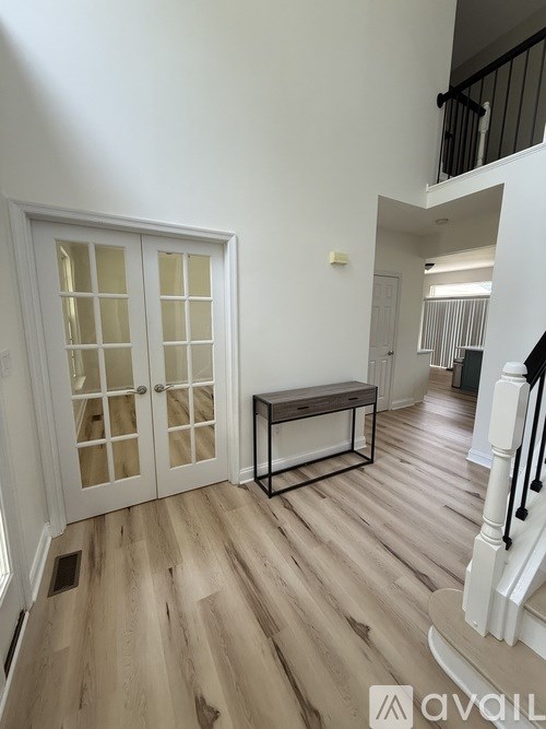 A room with a white door and a wooden floor.