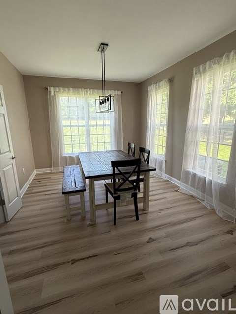 A dining room with a table and chairs.
