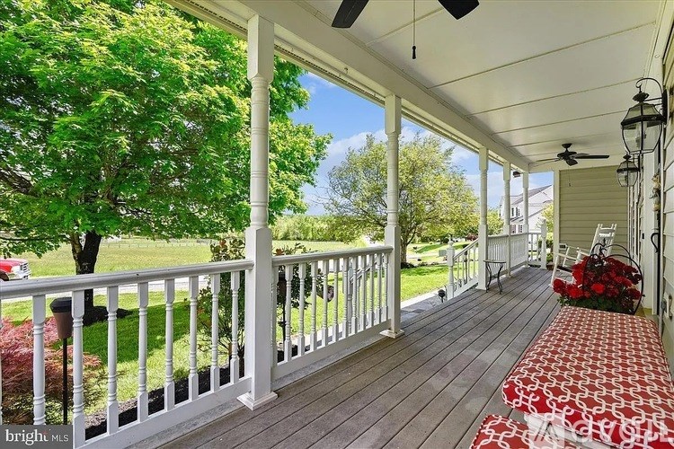 A porch with a red and white runner and a white railing.