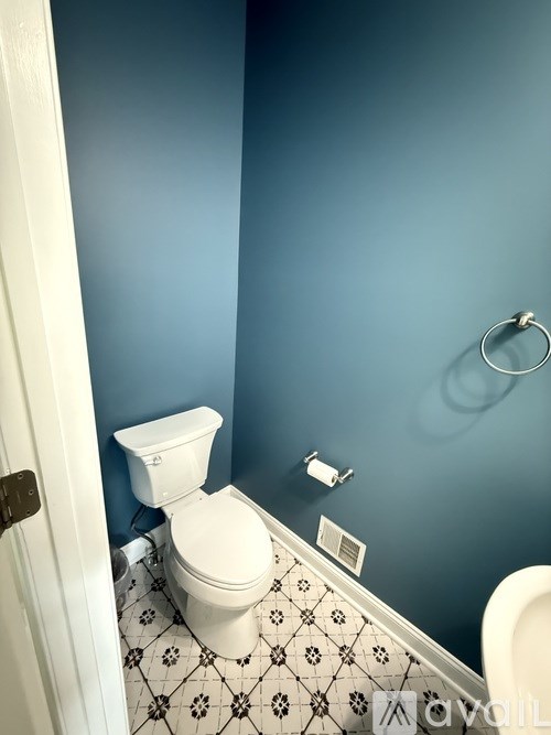A white toilet in a bathroom with blue walls.