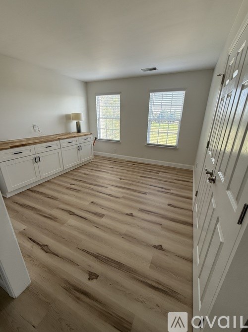 A room with wooden floors and white walls.