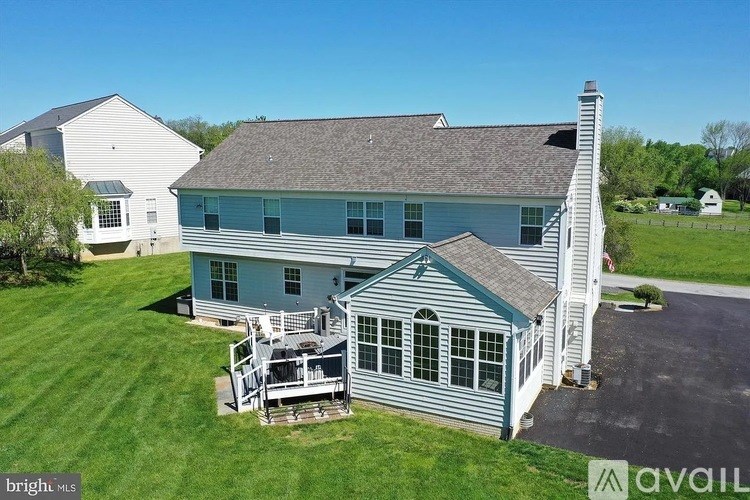 A house with a grey roof and a white house in the background.