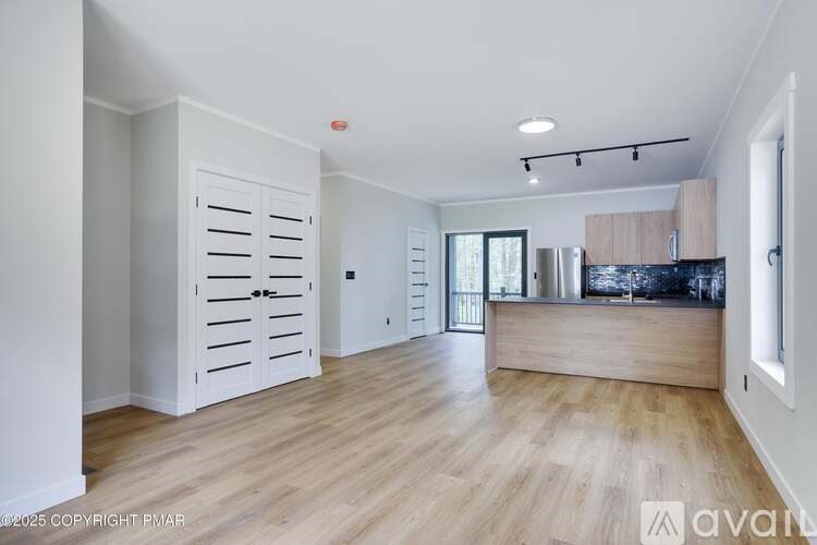 A spacious kitchen with wooden floors and a white cabinet.