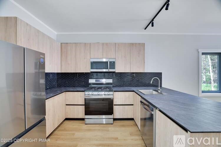 A modern kitchen with wooden cabinets and stainless steel appliances.