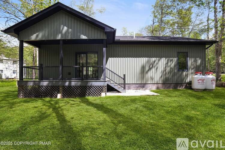 A house with a grey roof and a green lawn in front.