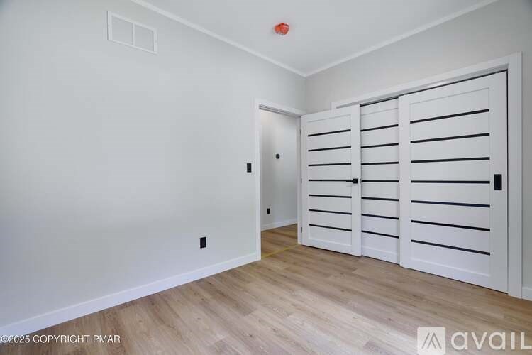 A room with a white door and a white wall.