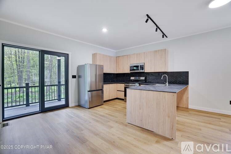 A kitchen with wooden cabinets and a black countertop is shown.
