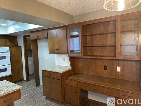 A kitchen with wooden cabinets and a granite countertop.