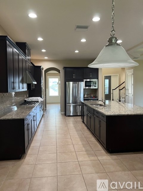 A modern kitchen with black cabinets and a central island.