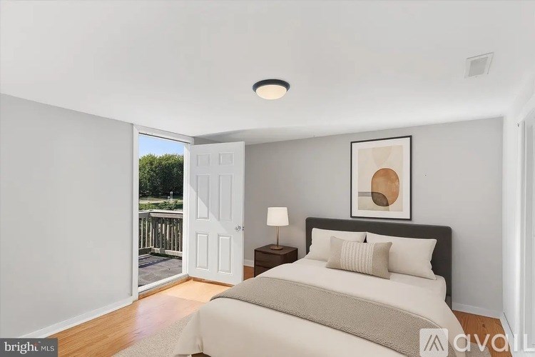 A bedroom with a large bed and a painting on the wall.