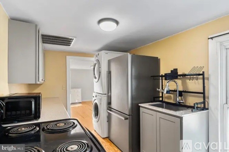 A kitchen with a stove top oven, microwave, and a washing machine.