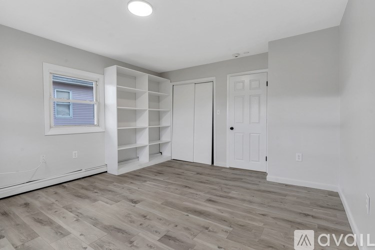 A room with a window and a door is available for rent.