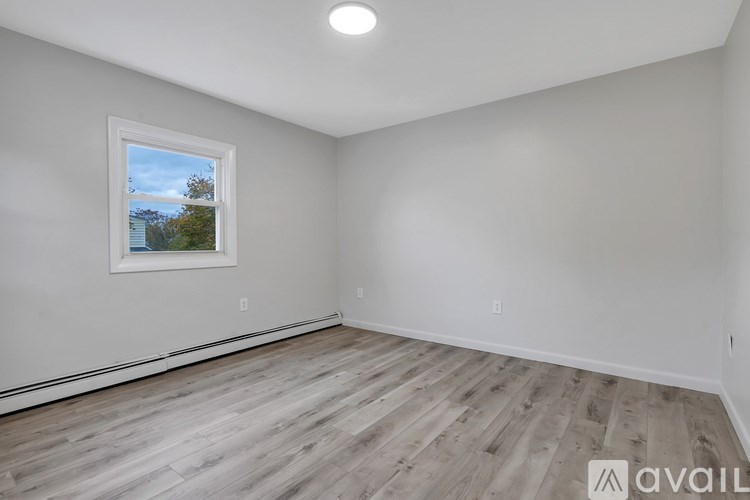 A room with a window and wooden flooring is available for rent.