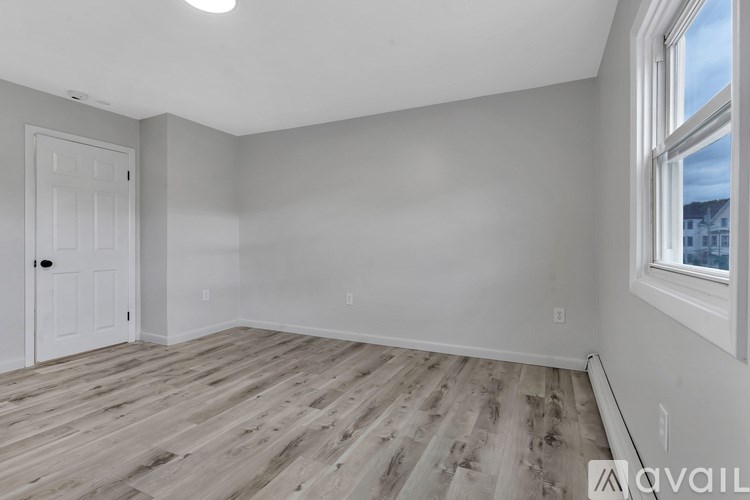 A room with wooden flooring and a window.