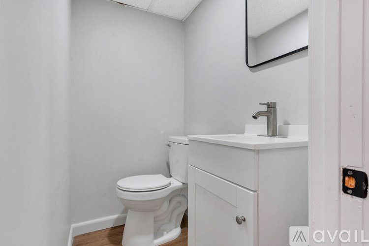 A white toilet and sink in a small bathroom.