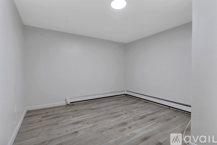 A room with wooden flooring and white walls.