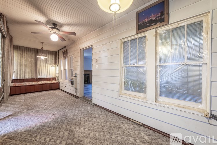 A room with a ceiling fan and a painting on the wall.