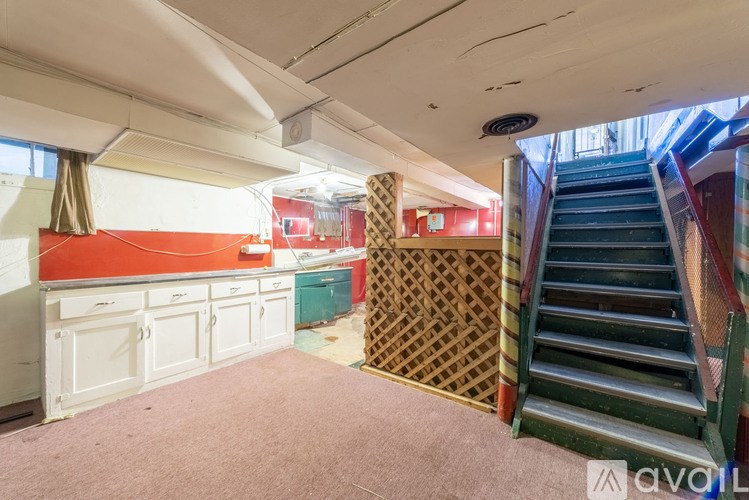 A room with a staircase and a white cabinetry.