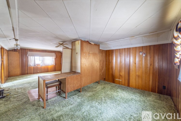 A room with wooden walls and a ceiling fan.