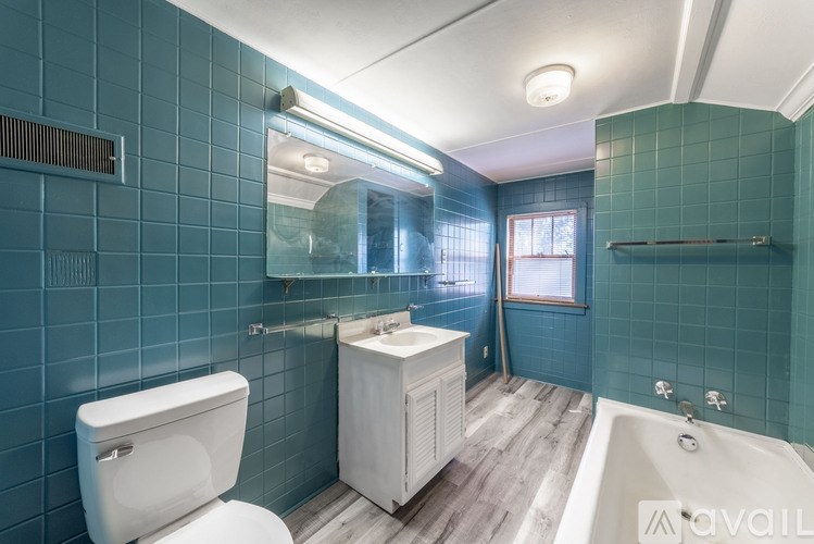 A bathroom with a white toilet, sink, and bathtub.