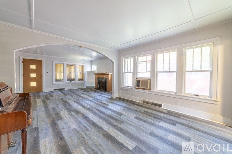 A spacious living room with a fireplace and a wooden bench.