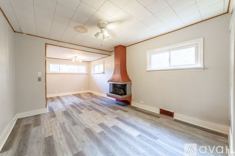 A room with a wood floor and a fireplace.