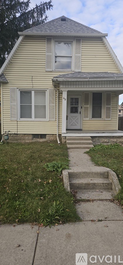 A yellow house with a grey door and windows.
