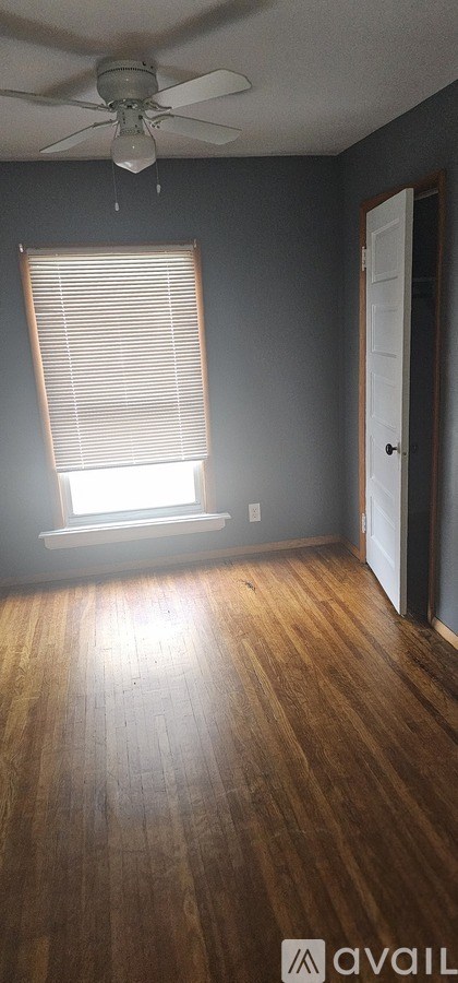 A room with wooden flooring and a ceiling fan.
