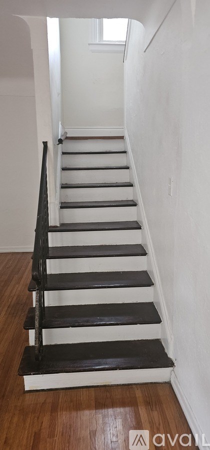 A staircase with a black railing and wooden steps.
