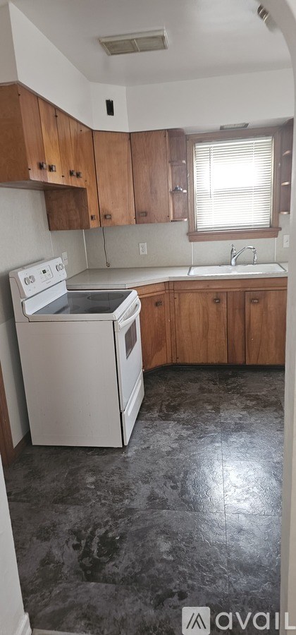 A kitchen with wooden cabinets and a white dishwasher.