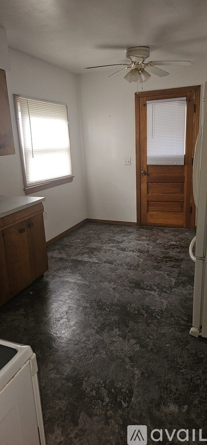 A room with a ceiling fan and a door leading to a balcony.