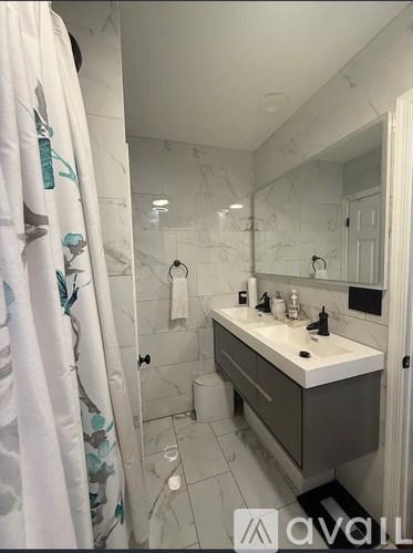 A bathroom with a white sink and a shower curtain with blue flowers.