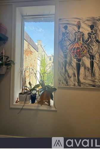 A painting of three women is on the wall next to a window.