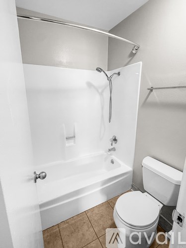 A white toilet sits next to a bathtub in a bathroom.