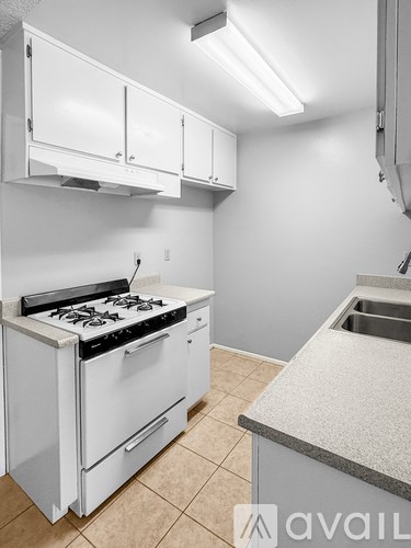 A kitchen with white appliances and cabinets.