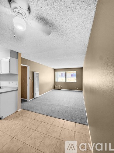 A room with beige walls and a grey carpet.