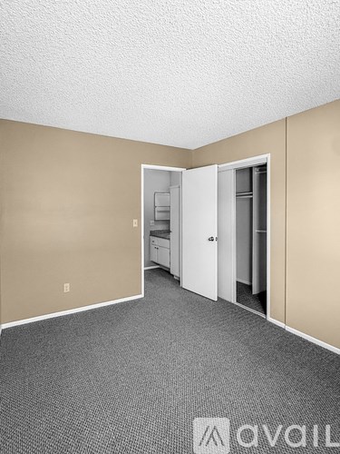 A room with a carpeted floor and a white door.