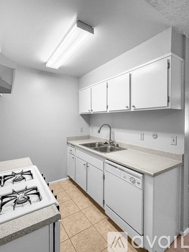 A kitchen with white cabinets and a stove top oven.