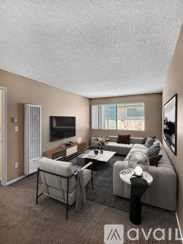 A living room with a grey couch, a coffee table, and a television.